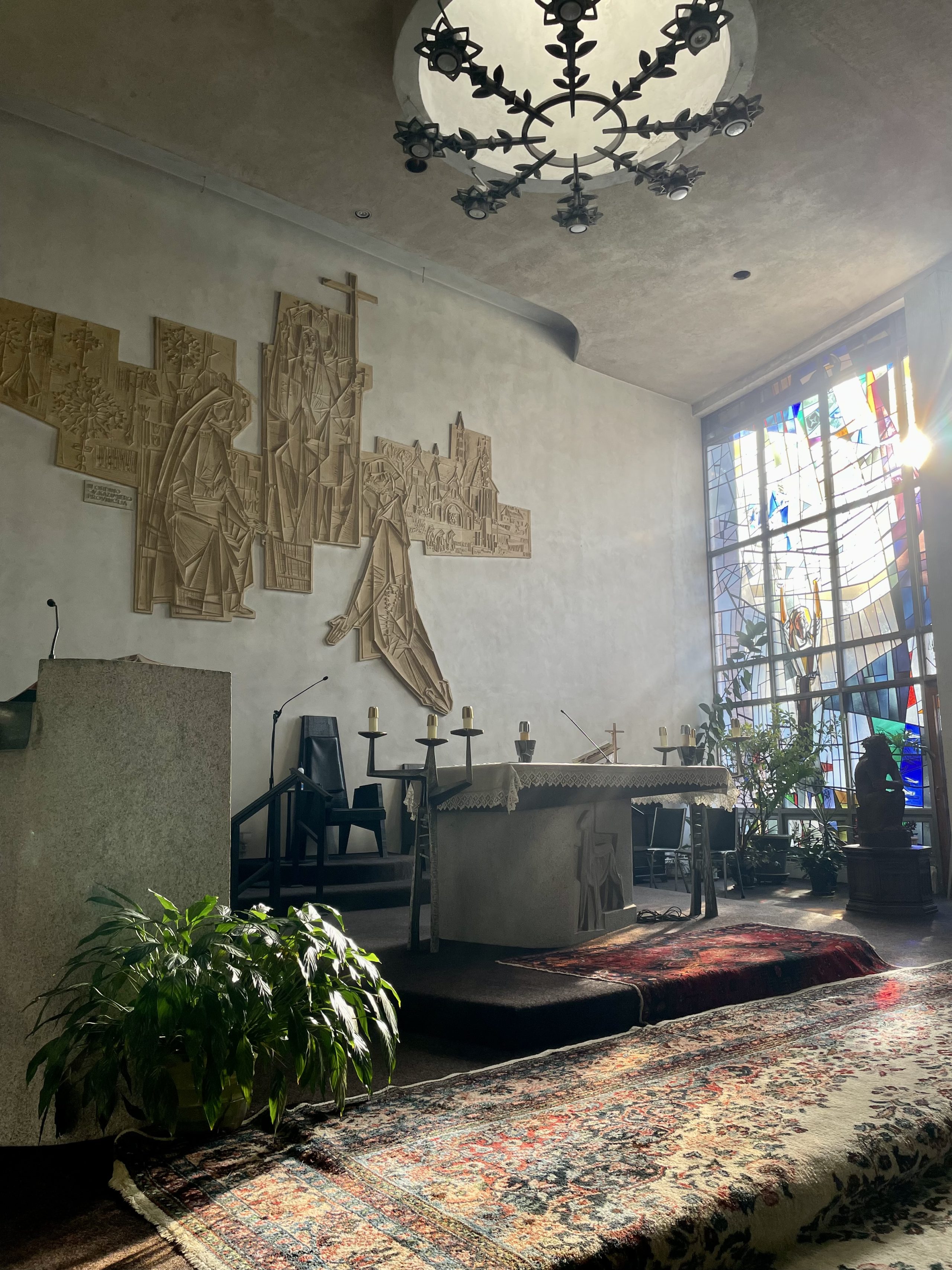 The interior of a Catholic church with light shining through the windows.